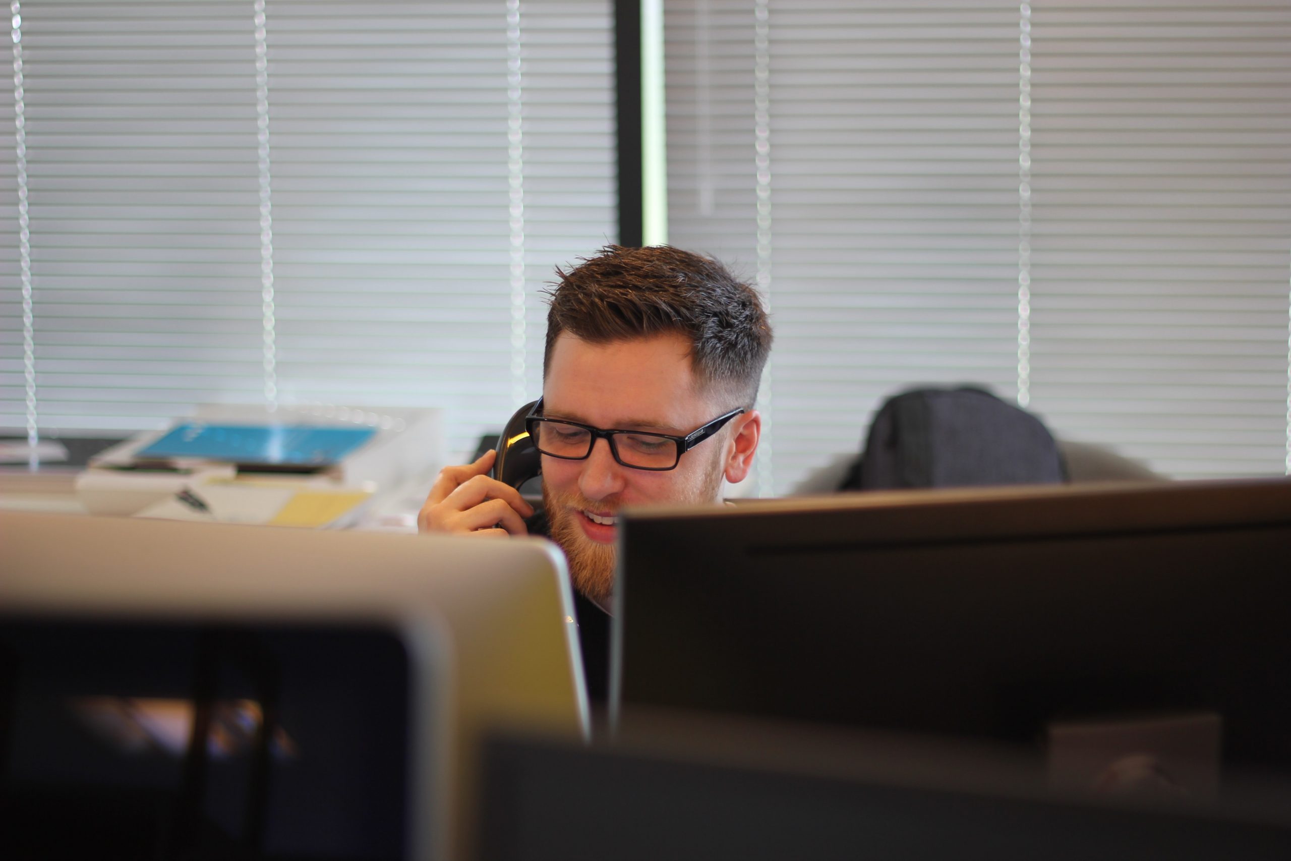 guy on phone to customer working from home. Although he is smiling, so maybe not a customer.