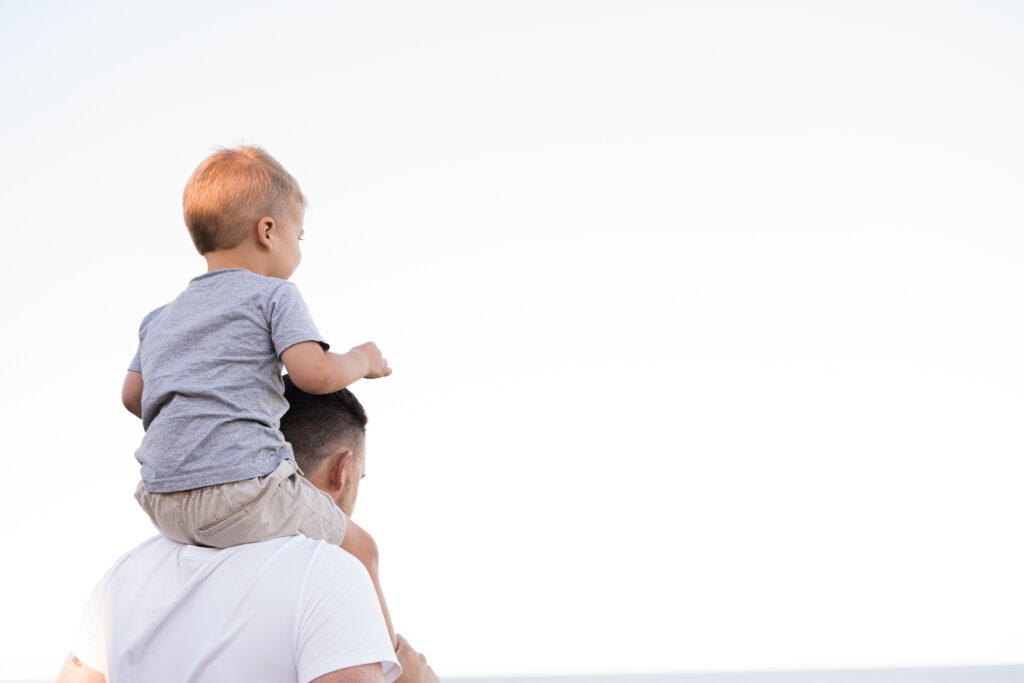 kid riding on dad's shoulders
