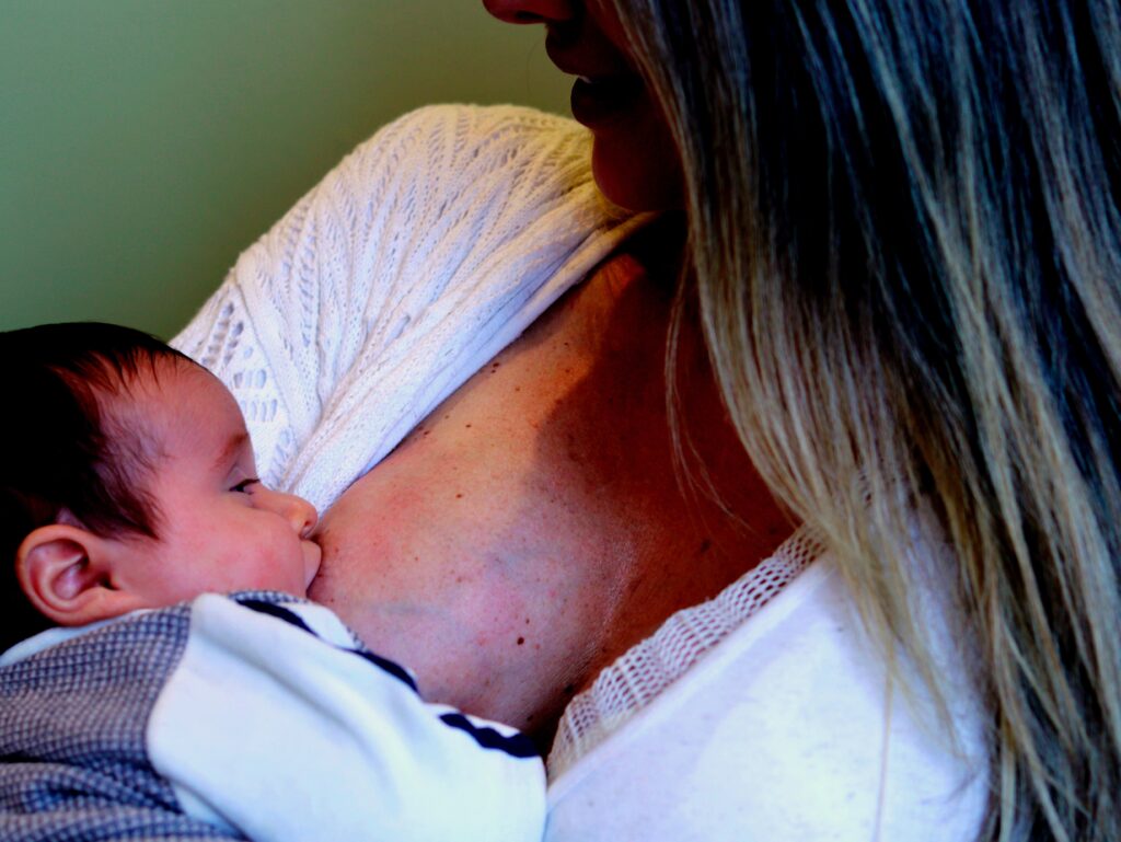 woman breastfeeding, perhaps with the help of a supportive dad, you never know!