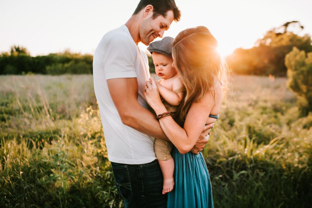 couple looking all smoochy with their new baby