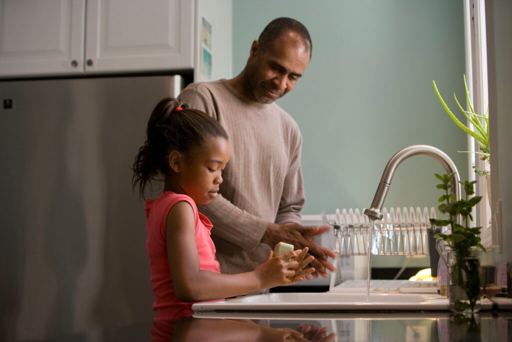 Father and daughter washing up