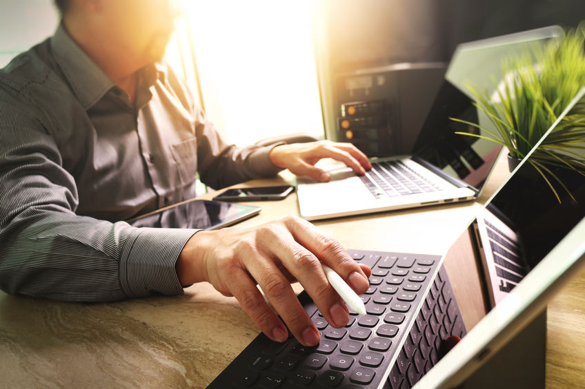 Outsource Developer working on marble Desk Working Laptop Computer Mobile Application Software and digital tablet dock smart keyboard,compact server,sun flare effect
