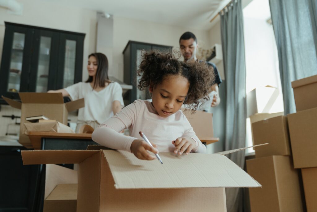 family with lots of boxes. child drawing on box