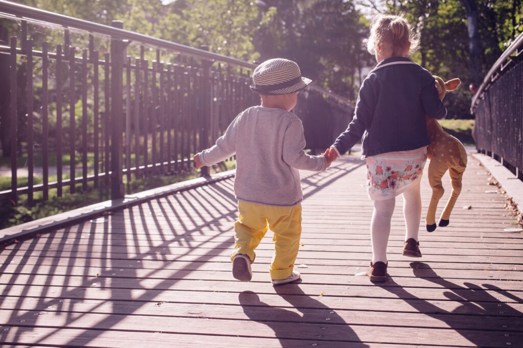 kids hand in hand on bridge