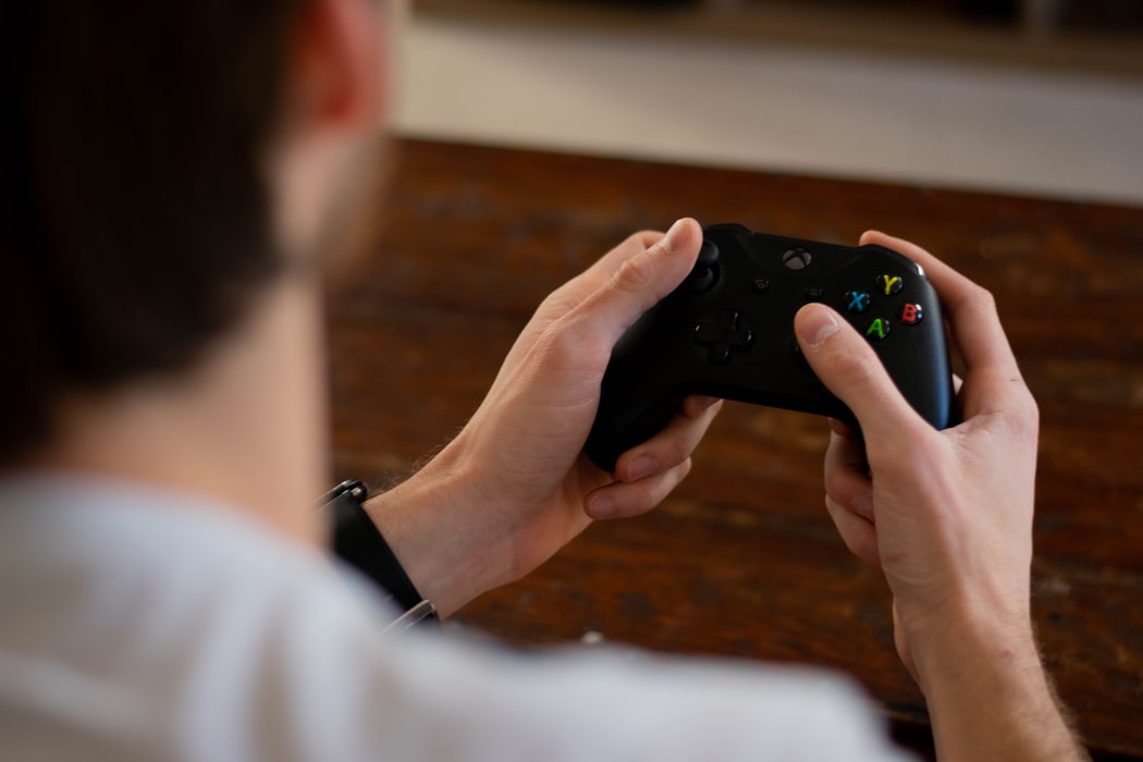 over shoulder shot of x box controller in hands