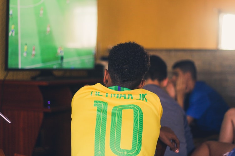 guy in Neymar Brazil top watching footy