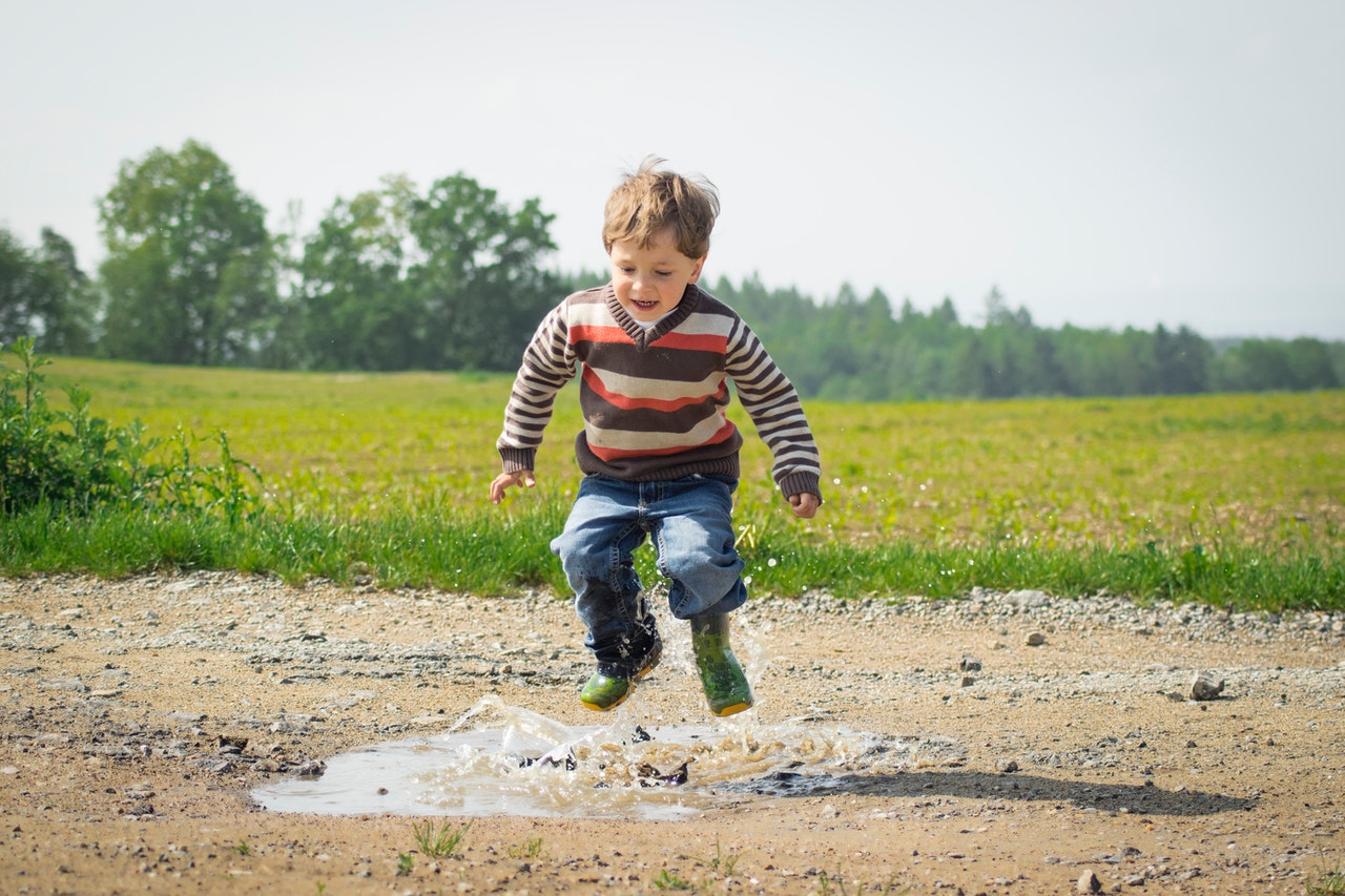 kid jumping in puddle