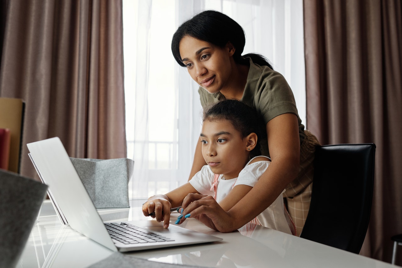 mother overseeing daughter's laptop use