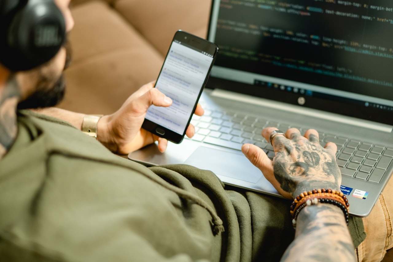 man on laptop and phone