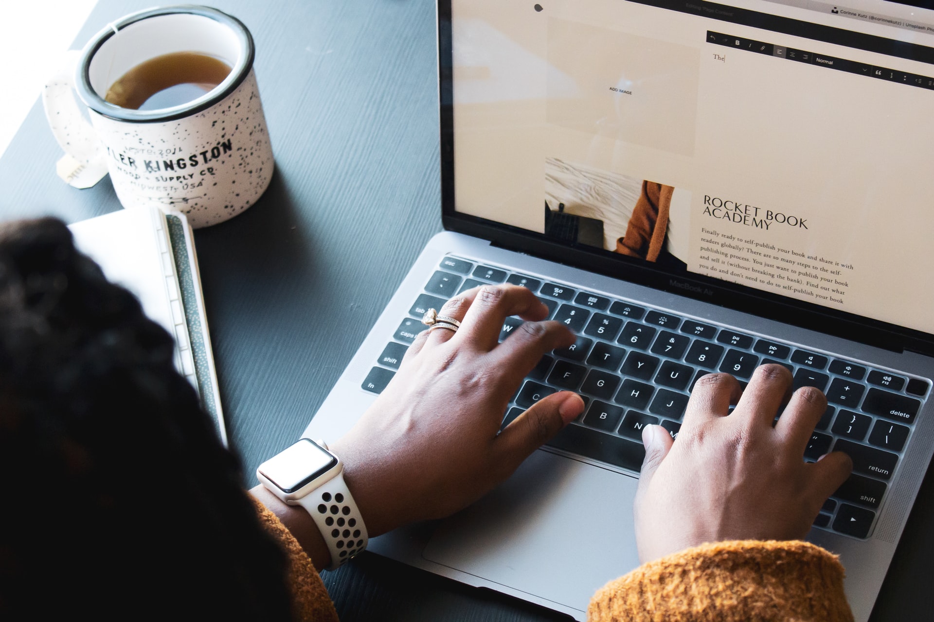 how I quit the day job after I started blogging - pic of an over the shoulder view of hands typing on a laptop keyboard.