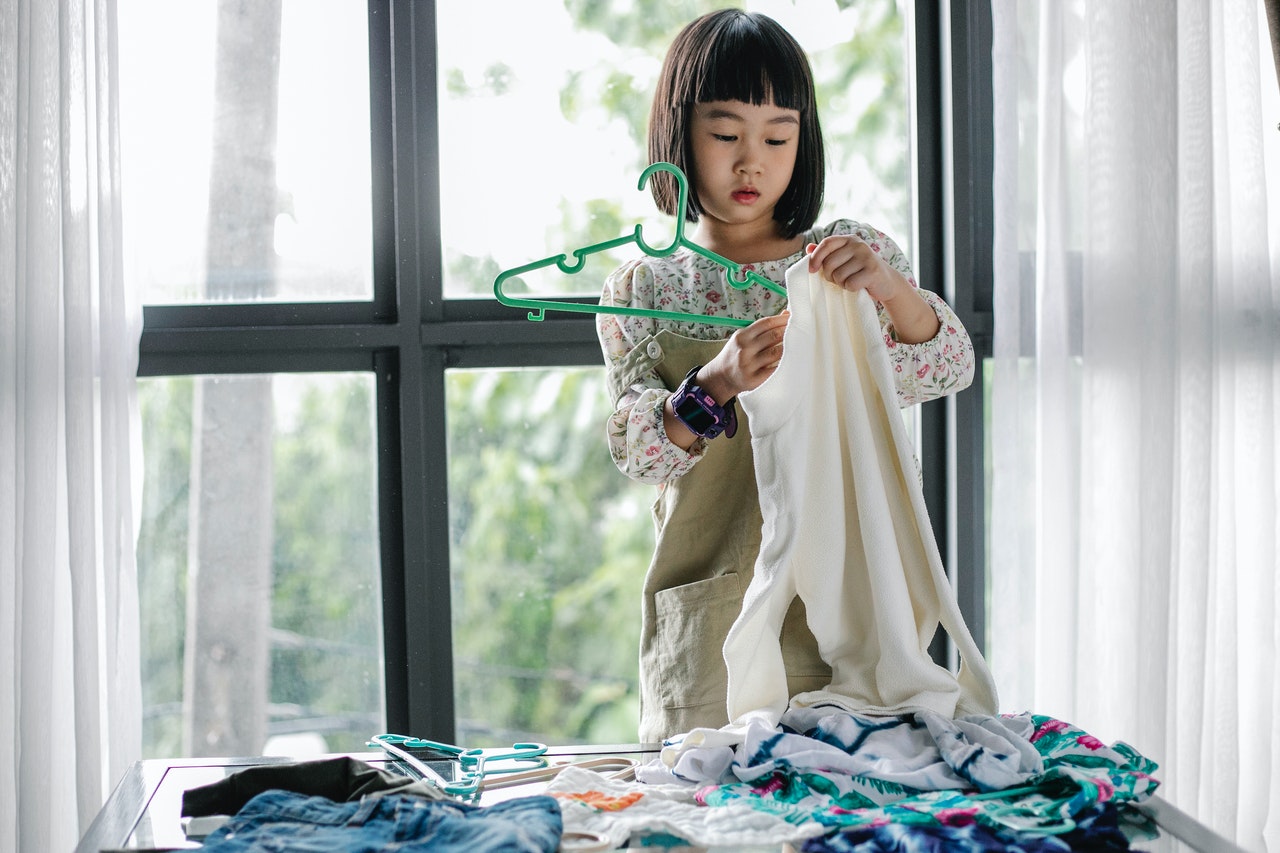young girl hanging clothes