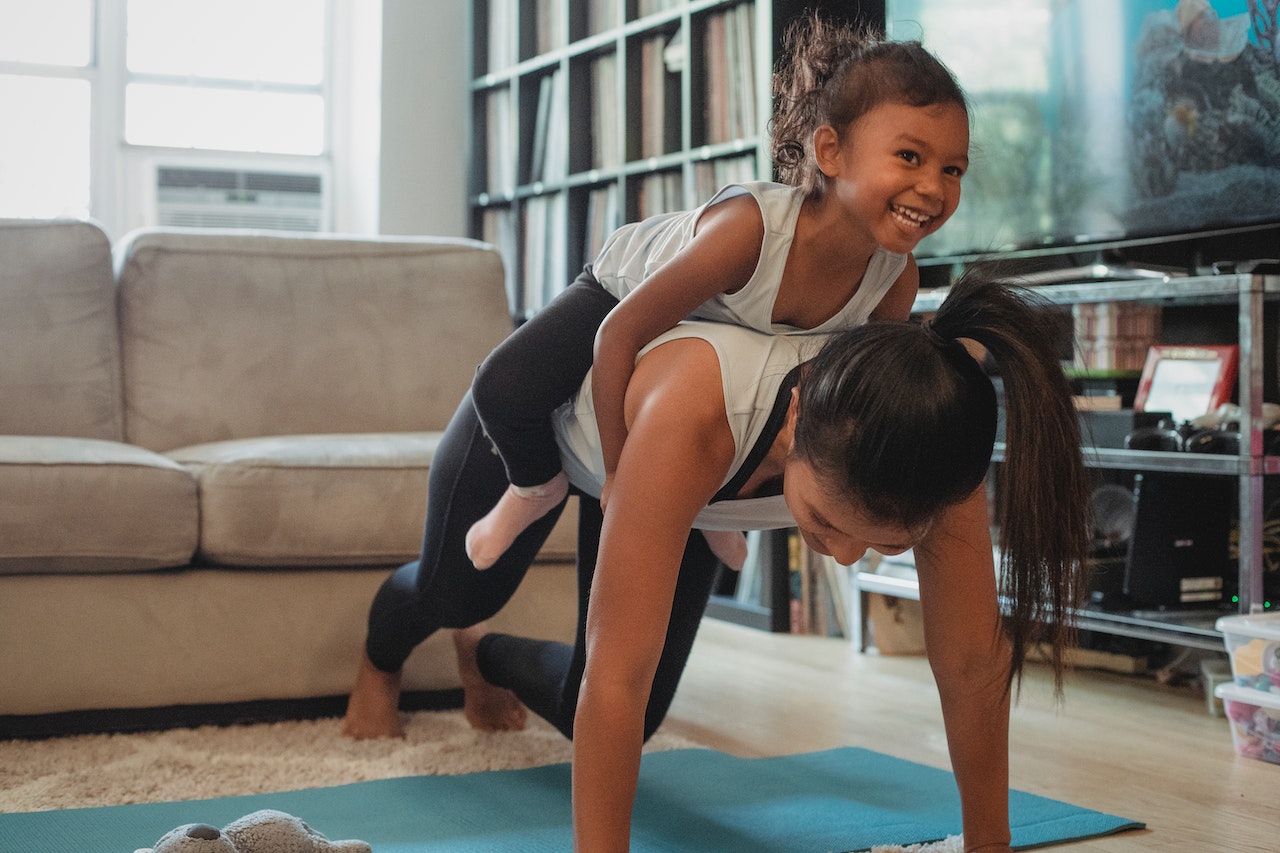 kid on mum's back doing press ups