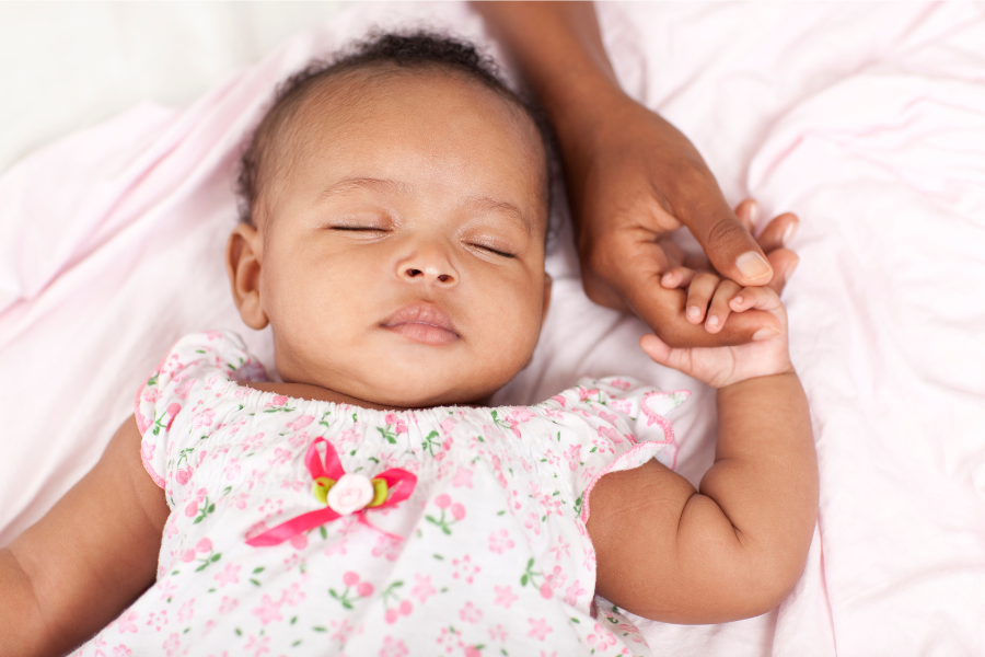 baby sleeping holding a hand