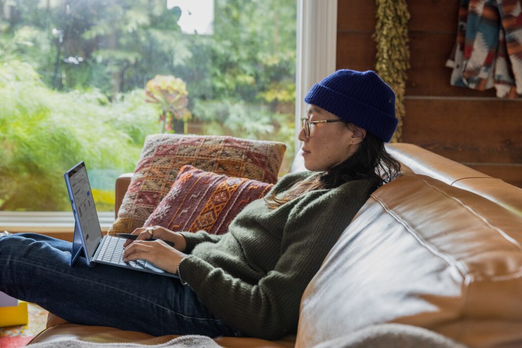 person sitting on sofa writing