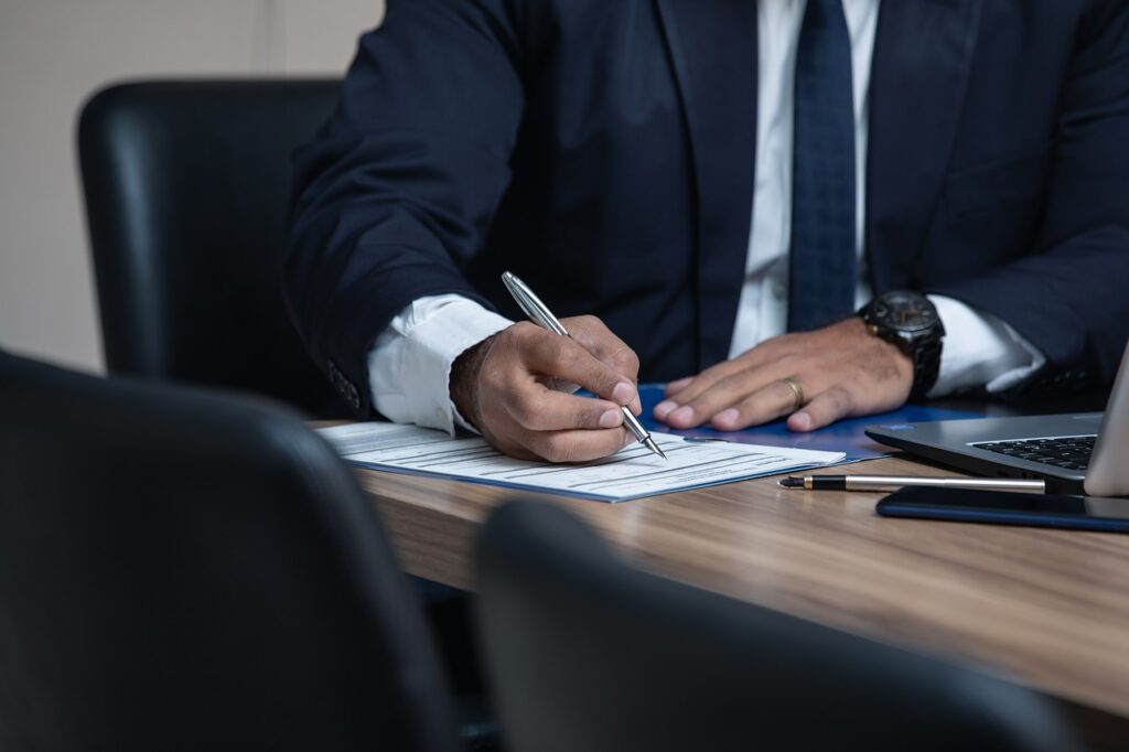 man signing documents