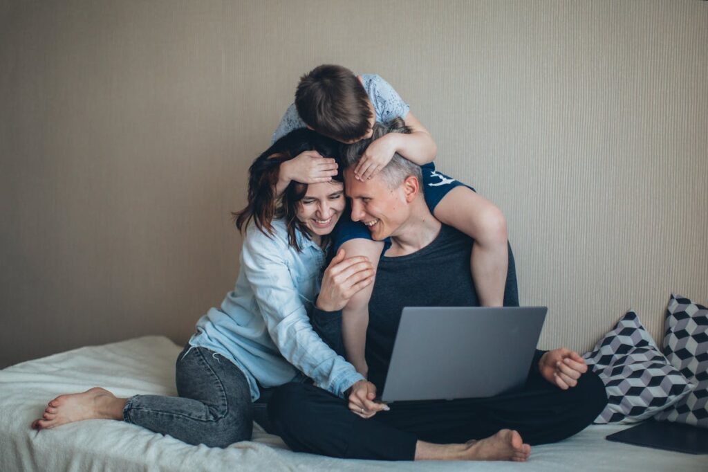 family using laptop and smiling